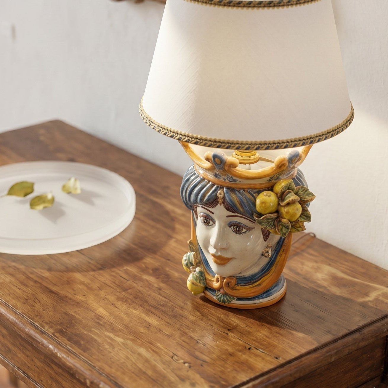Handmade ceramic Testa di Moro table lamp with fruit accents, traditional Sicilian design on wood surface