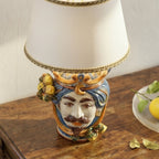 Handmade Teste di Moro table lamp with colorful ceramic face, blue turban, and lemon accents on wood surface