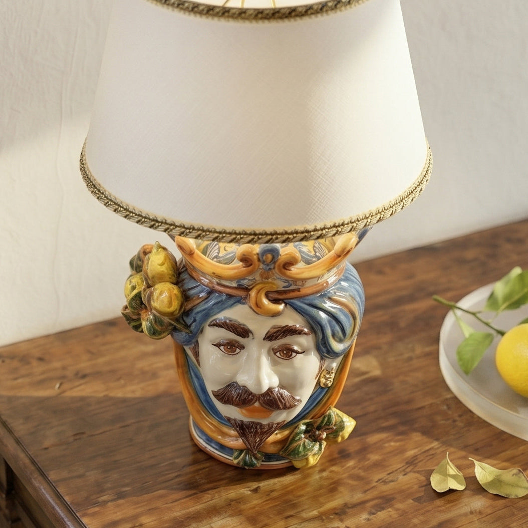Handmade Teste di Moro table lamp with colorful ceramic face, blue turban, and lemon accents on wood surface
