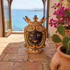 Handmade Teste di Moro ceramic vase with crown, set on terrace with sea view and pink flowers