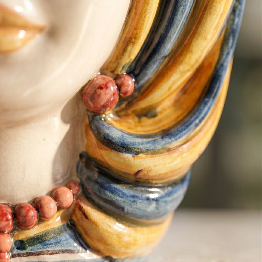 Handcrafted Teste di Moro ceramic with vibrant blue and gold swirls, red bead accents, and glossy finish
