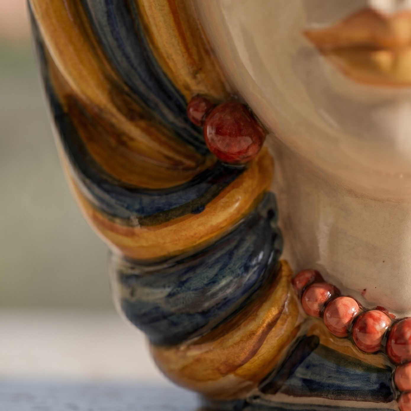 Handcrafted Teste di Moro ceramic with vibrant blue, amber, and red glaze details