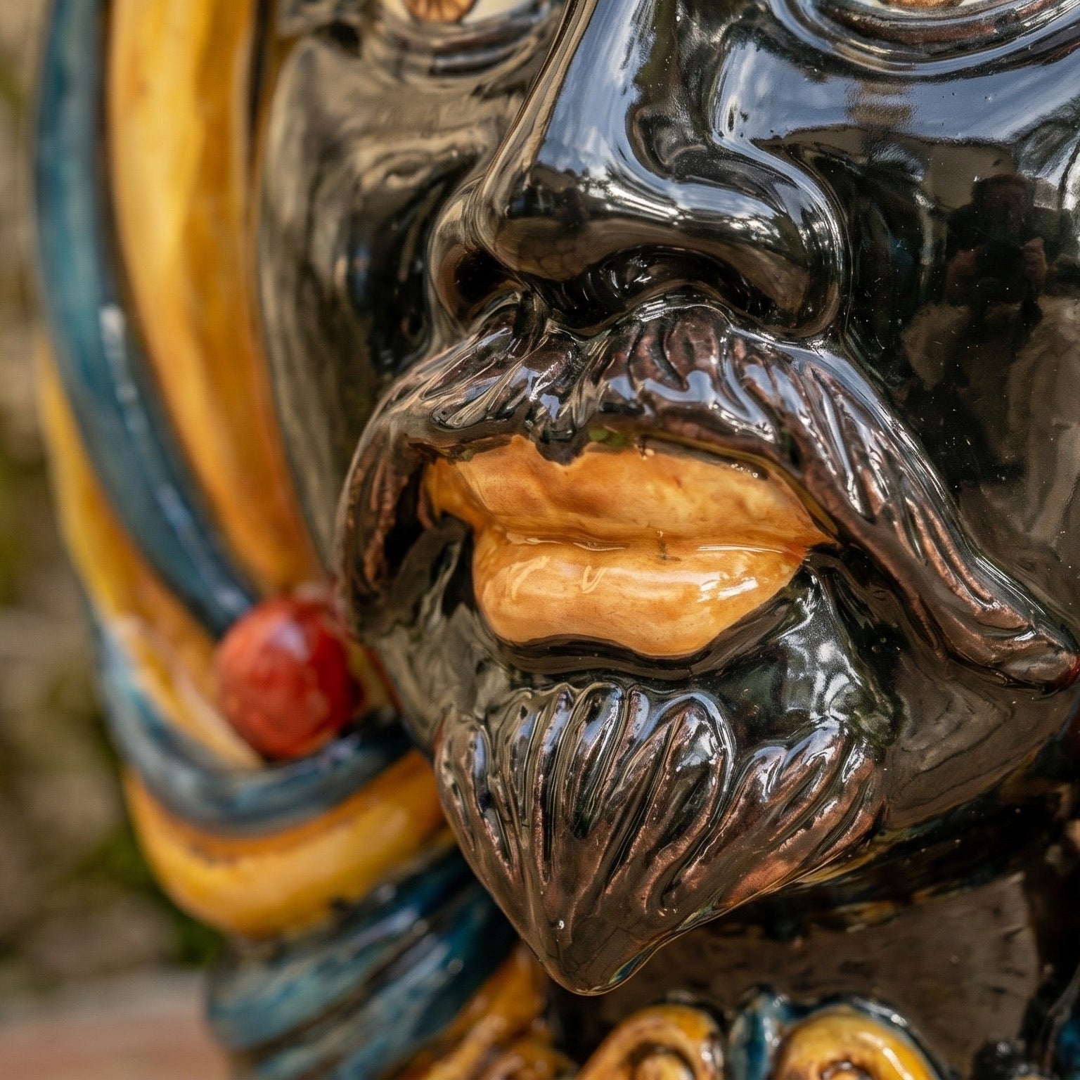 Handcrafted Teste di Moro ceramic face with glossy black glaze, vibrant colors, and detailed beard, blending tradition with modern design.