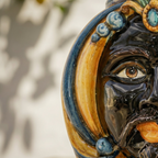 Handcrafted Teste di Moro ceramic face with vibrant blue and gold glaze, traditional Sicilian art