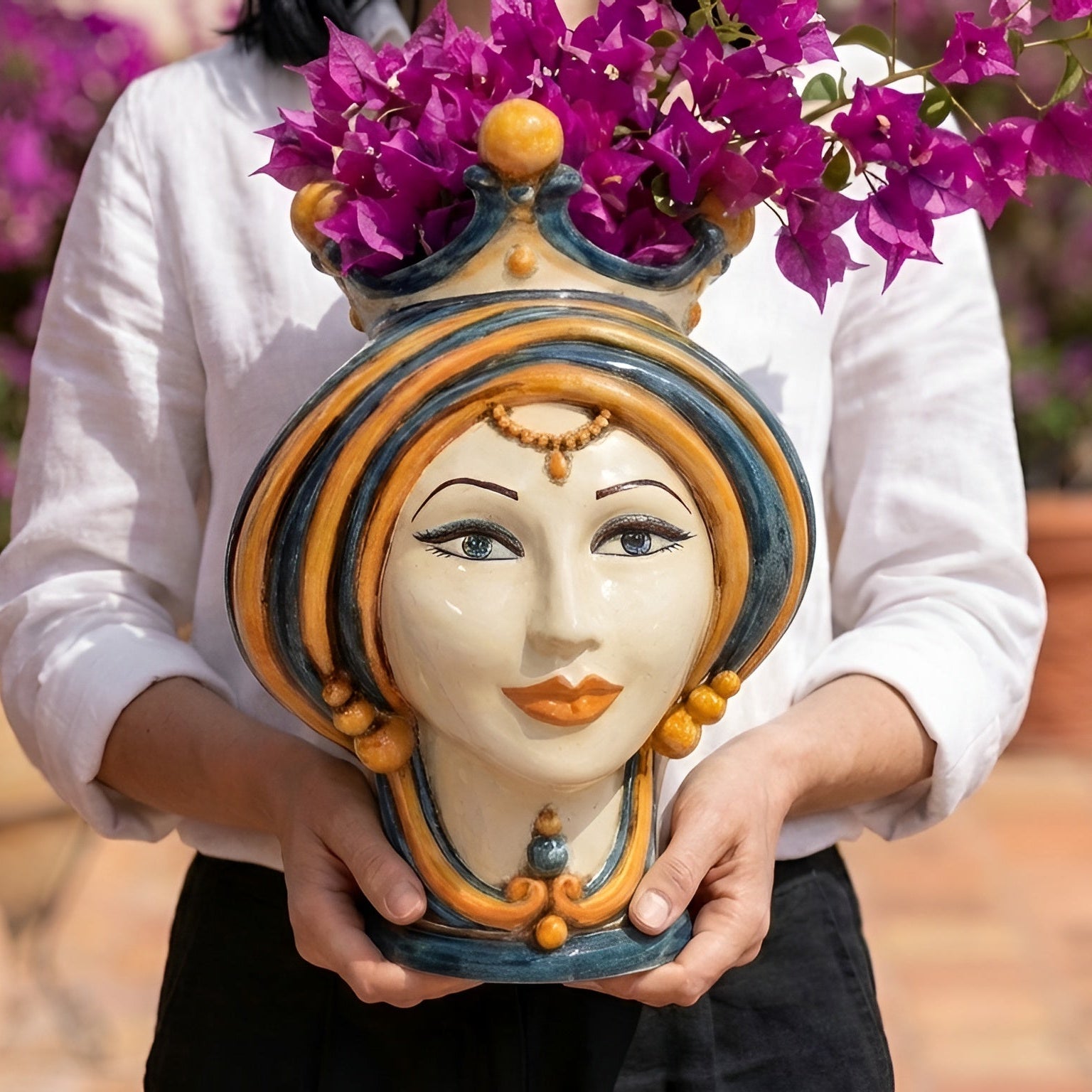 Handmade Teste di Moro vase with vibrant purple flowers, featuring traditional Sicilian design and colorful ceramic details.