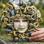 Medusa head with blue beads and green lips on a wall, hand-modelled green and blue snakes