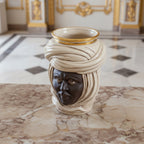 Handcrafted Teste di Moro vase with turban, gold accents, on marble surface in elegant interior