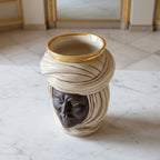 Handmade Teste di Moro vase with turban, gold rim, on marble surface — traditional Sicilian decor