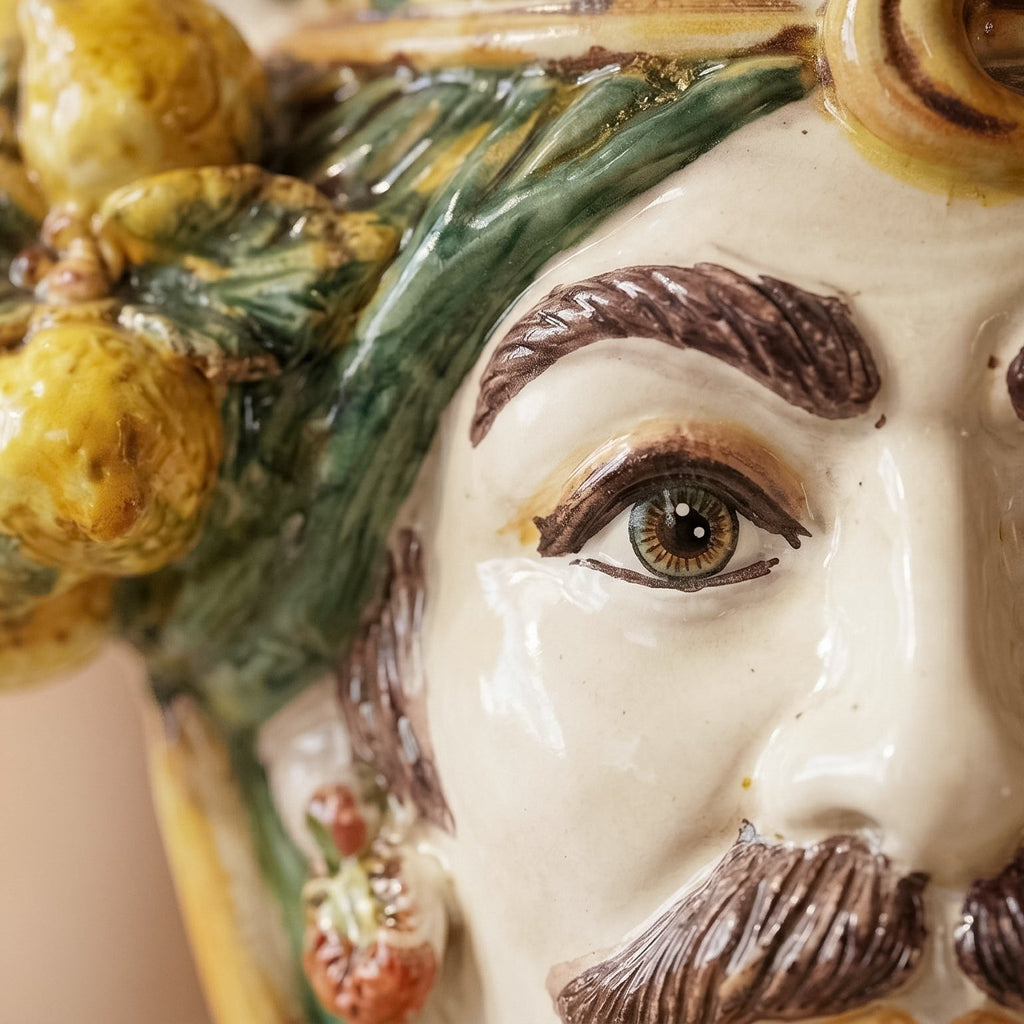 Handcrafted Teste di Moro ceramic with detailed eye, green leaves, and yellow fruit, blending tradition and modern design.