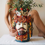 Hand-painted Moorish head vase with floral crown, holding olive branches, traditional Sicilian ceramic decor