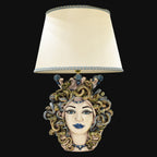 Handmade Medusa head table lamp with snake hair, blue accents, and cream shade, blending tradition and modern design.