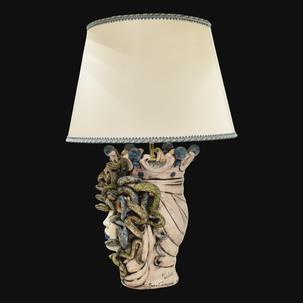 Handcrafted Medusa head table lamp with snake details and cream shade, blending tradition and modern design