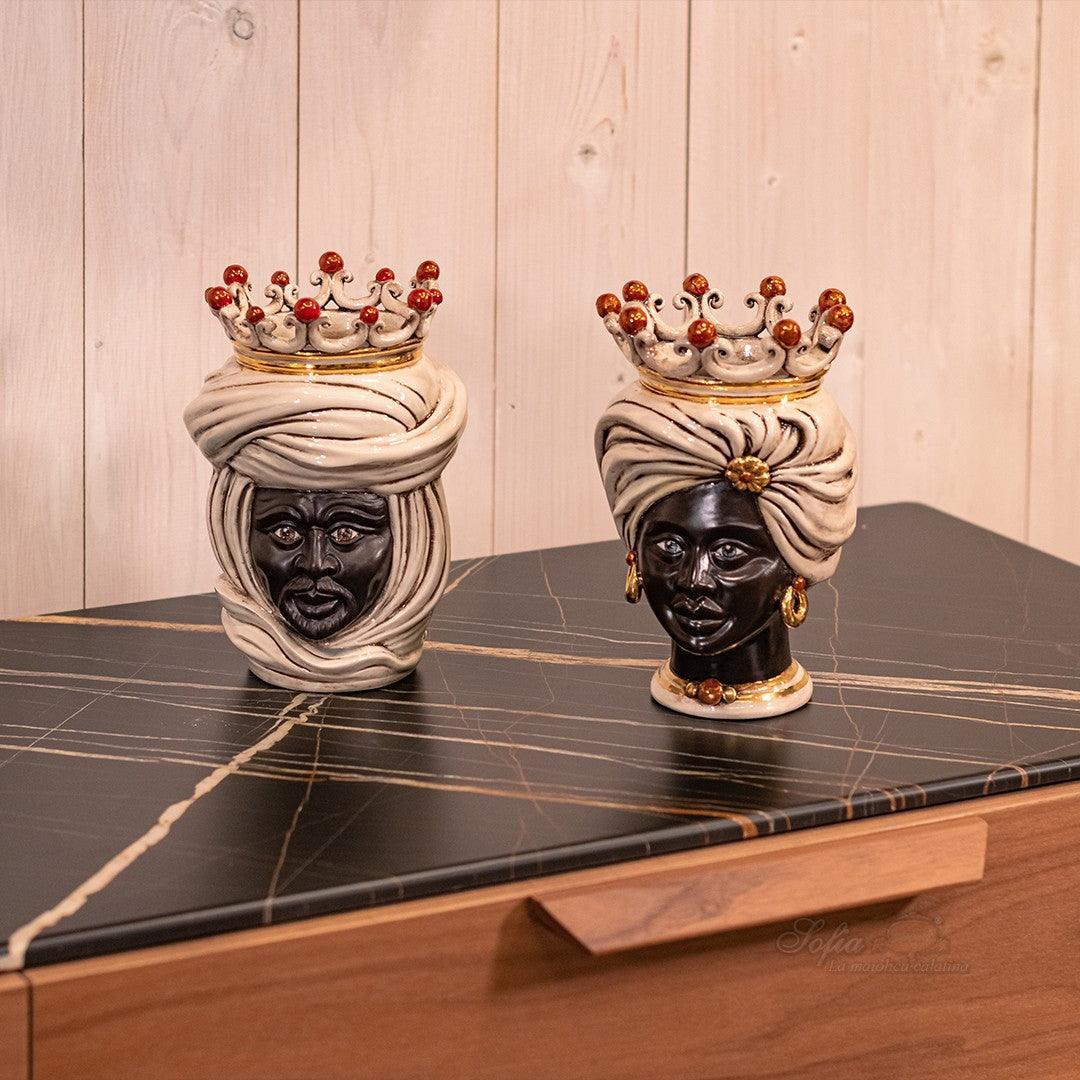 Handcrafted Teste di Moro ceramic heads with crowns, displayed on marble surface, blending tradition and modern design.