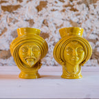 Handmade yellow Teste di Moro vases with male and female faces, traditional Sicilian ceramic decor