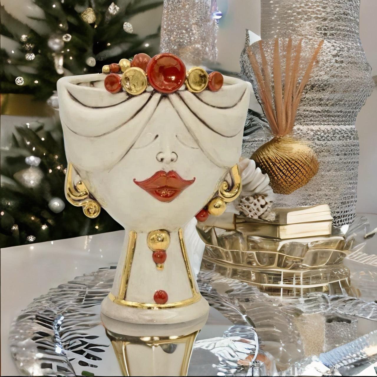 Handcrafted Teste di Moro ceramic vase with red lips, gold accents, and festive holiday decor background