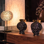 Handcrafted black Teste di Moro vases with gold accents, displayed on wood console with modern lamp