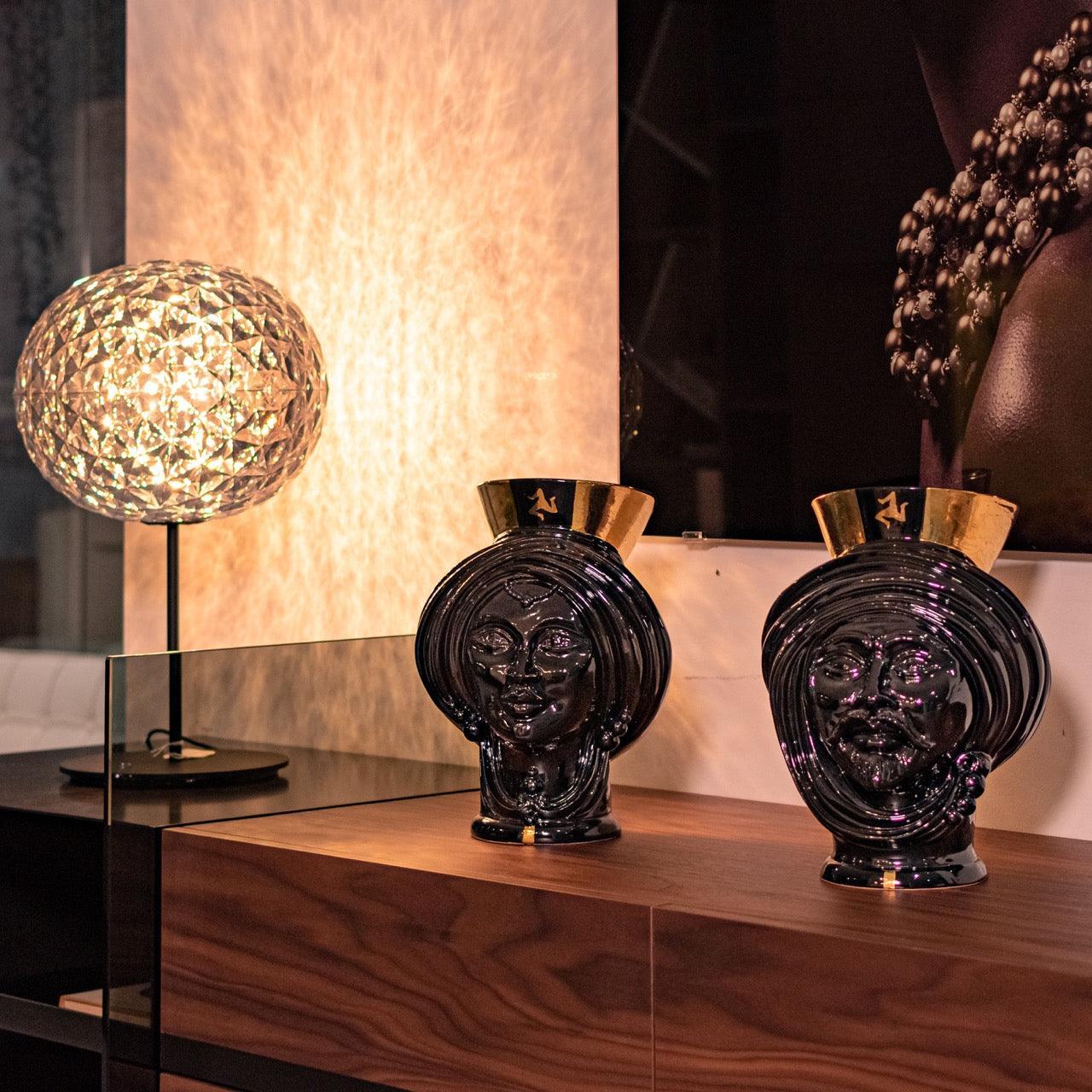 Handcrafted black Teste di Moro vases with gold accents, displayed on wood console with modern lamp