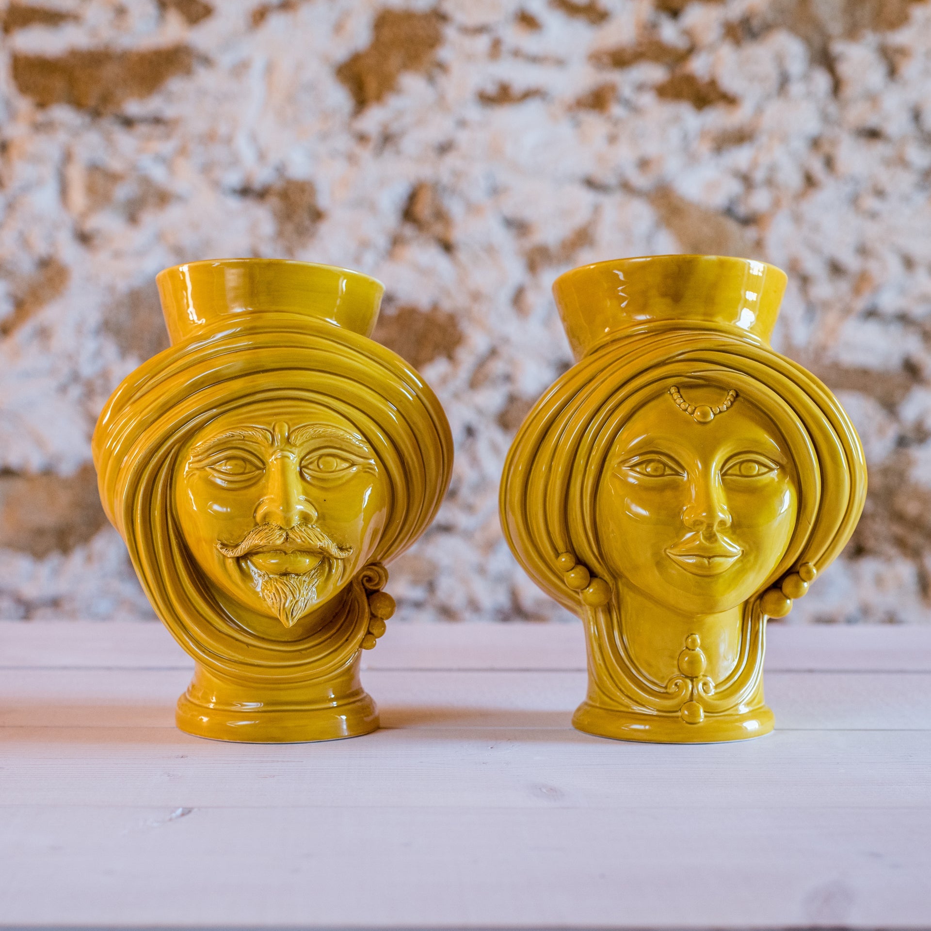 Handmade yellow Teste di Moro ceramic vases with male and female faces, traditional Sicilian decor