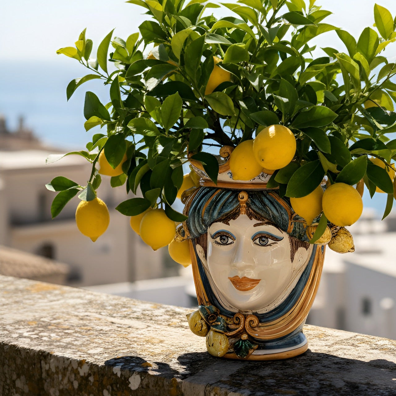 Handmade Teste di Moro planter with lemon tree, blending Sicilian tradition and modern design outdoors.