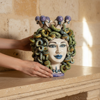 Handcrafted Teste di Moro ceramic head with serpent hair and purple crown, held on stone mantel