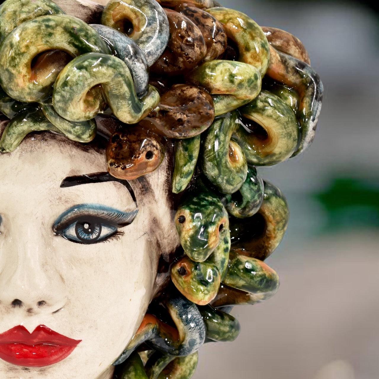 Handmade ceramic Teste di Moro with vibrant green and brown glazed snakes, bold blue eyes, and red lips