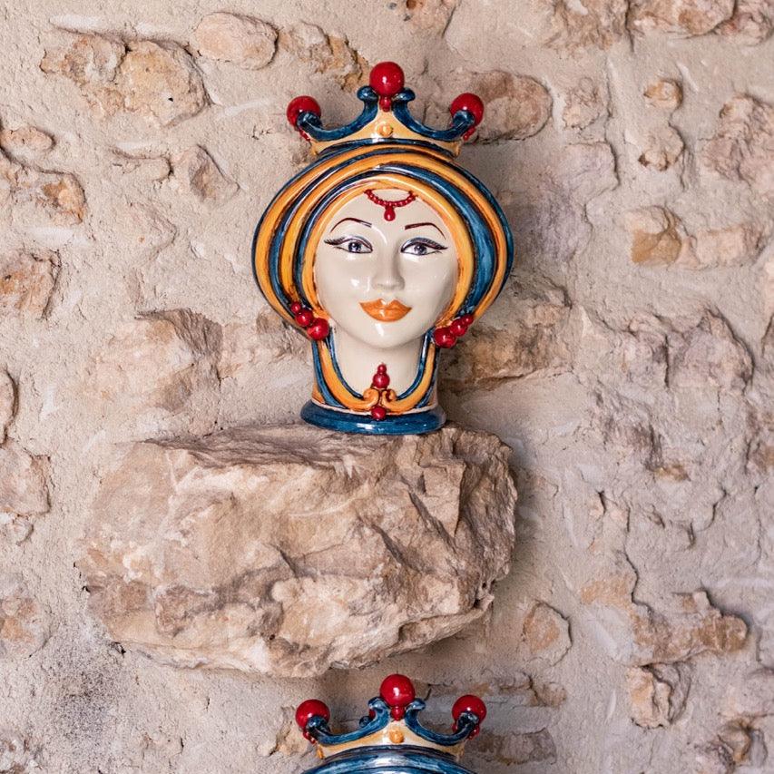 Handcrafted Teste di Moro ceramic wall decor with vibrant crown, displayed on rustic stone against textured wall