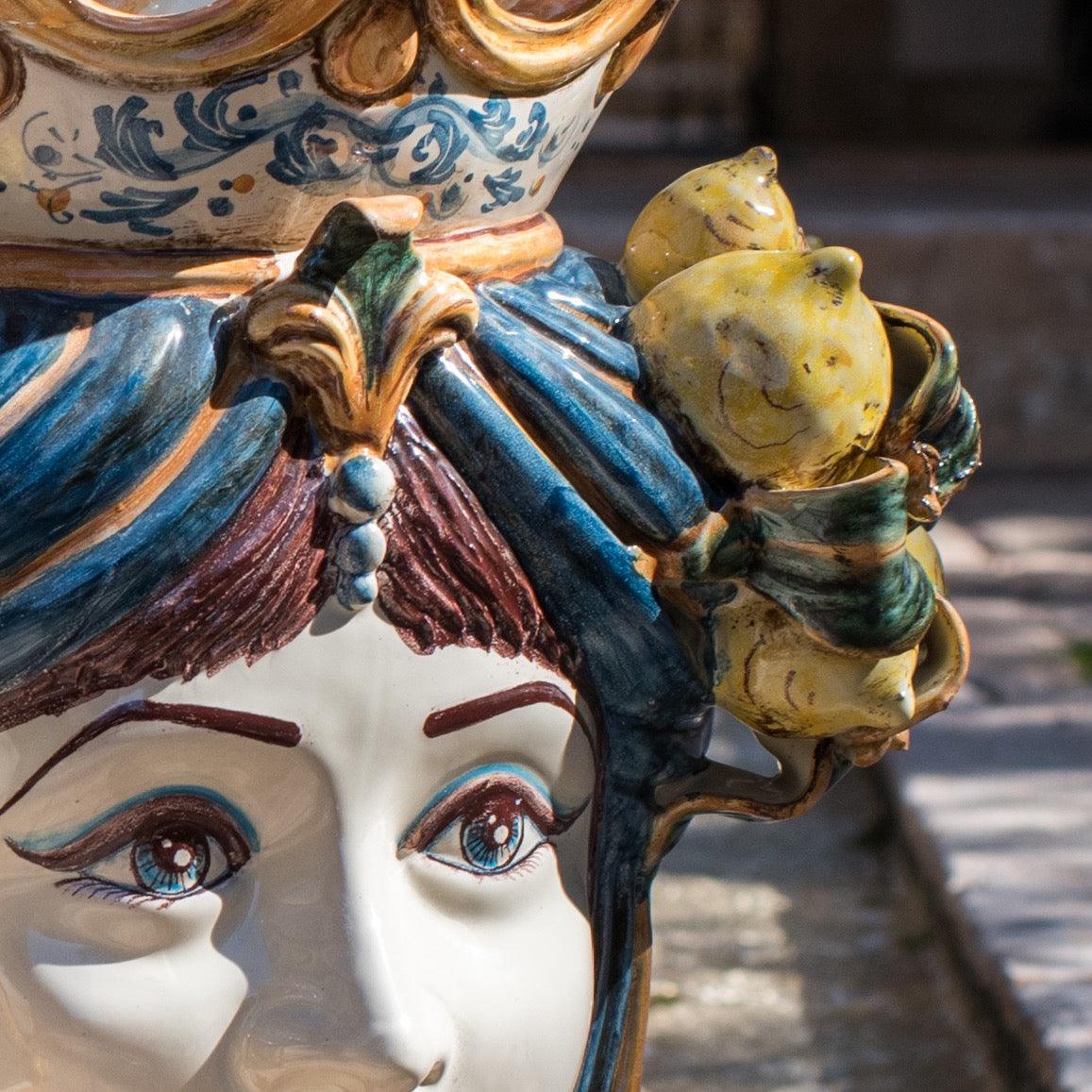 Handcrafted Teste di Moro ceramic with vibrant blue hair, detailed eyes, and lemon accents, blending tradition and modern design.