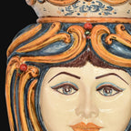 Handcrafted Teste di Moro ceramic face with vibrant blue and orange swirls, detailed eyes, and traditional Sicilian design.