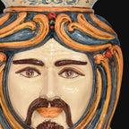 Handcrafted Teste di Moro ceramic face with vibrant blue and orange swirls, detailed eyes, and mustache
