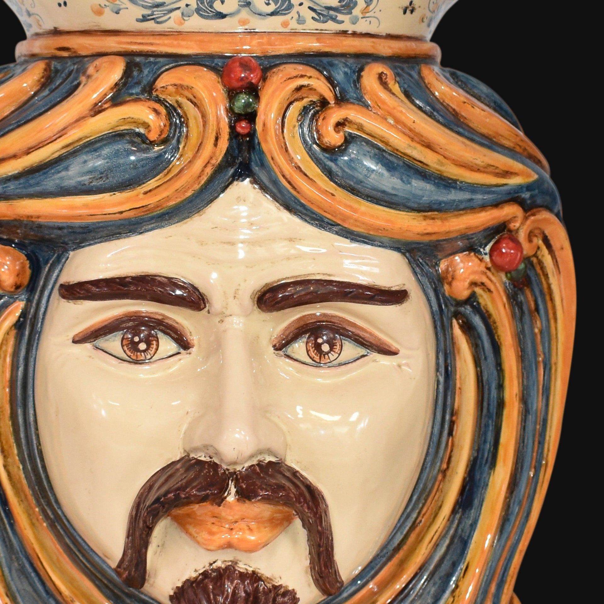 Handcrafted Teste di Moro ceramic face with vibrant blue and orange swirls, detailed eyes, and mustache