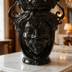 Handcrafted black Teste di Moro vase with ornate scrollwork, displayed on marble surface